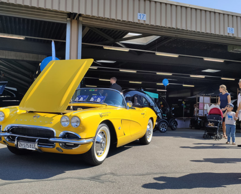 emobilitaet_zug21_2 Eine gelbe Corvette Jahrgang 1962 steht mit offener Motorenhaube vor einer Halle.