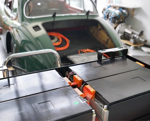 DSC00556_jaguarXK150_batterie10 Im Vordergrund die hintere Batteriebox mit Batteriemodulen befüllt. Im Hintergrund das Heck des Jaguars XK150.