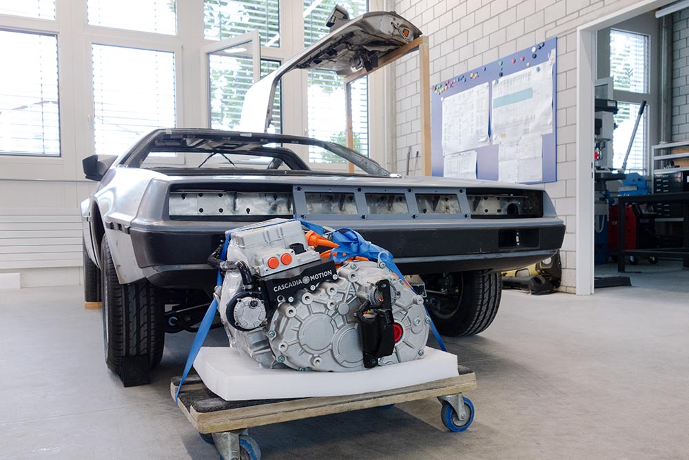DSC03961_deLorean_manufakturmarton_galerie7 Der Elektromotor plus Umrichter und Getriebe/Differenzial auf einem Rollbrett vor dem Fahrzeug.