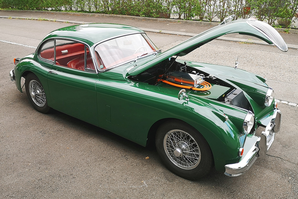 Jaguar XK 150, halbseitliche Ansicht, das Fahrzeug steht mit offener Haube da.