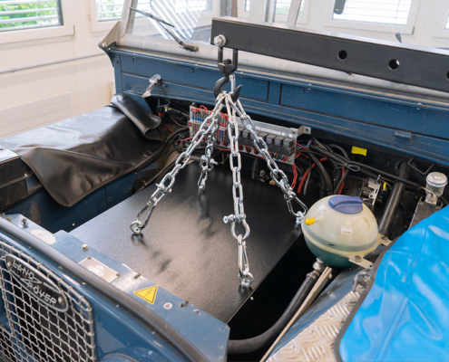 eLandy_manufakturmarton_galerie_03321 Einbau der Batteriekiste in den ehemaligen Motorraum des eLandys. Die Kiste ist an vier Haken mit Ketten an einem Kran befestigt und wird so hineingehoben.