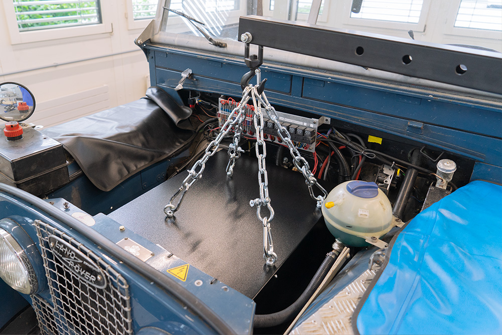 eLandy_manufakturmarton_galerie_03321 Einbau der Batteriekiste in den ehemaligen Motorraum des eLandys. Die Kiste ist an vier Haken mit Ketten an einem Kran befestigt und wird so hineingehoben.