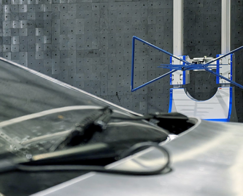 EMV Prüfung DeLorean Ein DeLorean wird gerade auf seine elektromagnetische Verträglichkeit geprüft. Er steht in einer Prüfhalle, eine blaue Antenne ist auf ihn gerichtet und misst seine elektromagnetischen Strahlungswerte. Man sieht im Bild Teile der Frontscheibe sowie der Fronthaube, ein Kabel, und im Hintergrund eine auf das Fahrzeug gerichtete Antenne