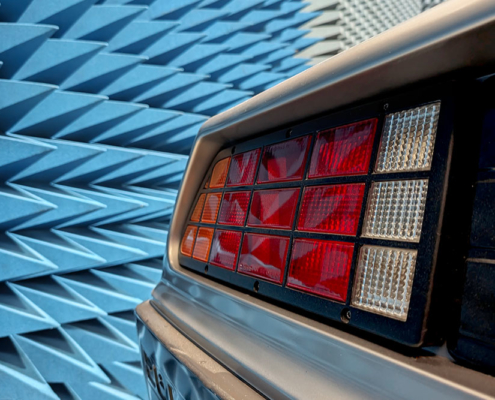 EMV Testlabor DeLorean Ein Teil des Hecks des DeLoreans in einer Prüfhalle für elektromagnetische Immunität. Im Hintergrund die Wand der Halle, an der blaue Pyramidenabsorber angebracht sind.