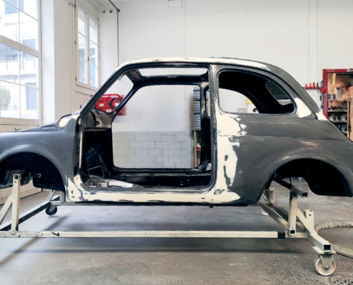Die Karosserie des Fiat 500, mehrheitlich schwarz von der KTL-Lackierung. Einzelne Stellen sind heller, dort wurden unebenheiten aufgefüllt zur Vorbereitung für die Lackierung