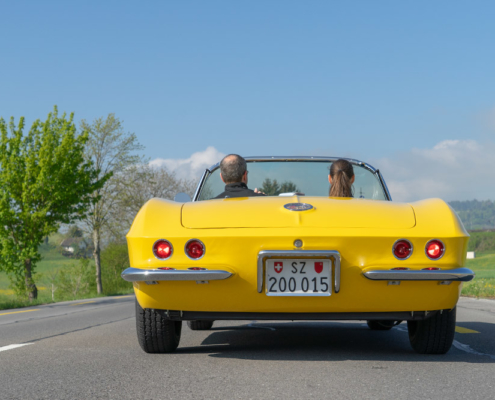 Corvette fährt los Ansicht fahrende Corvette von hinten mit zwei Insassen