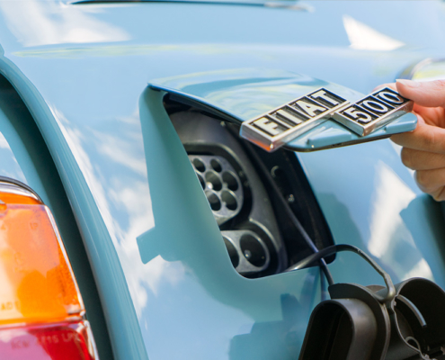 DSC00602_manufakturmarton_webgallerie Eine Öffnung am Heck des blau lackierten Fiat 500, die mit einer Klappe in Wagenfarbe verschlossen werden kann. Im Bild ist diese halb geöffnet, an ihr ist das Logo "Fiat 500" angebracht.